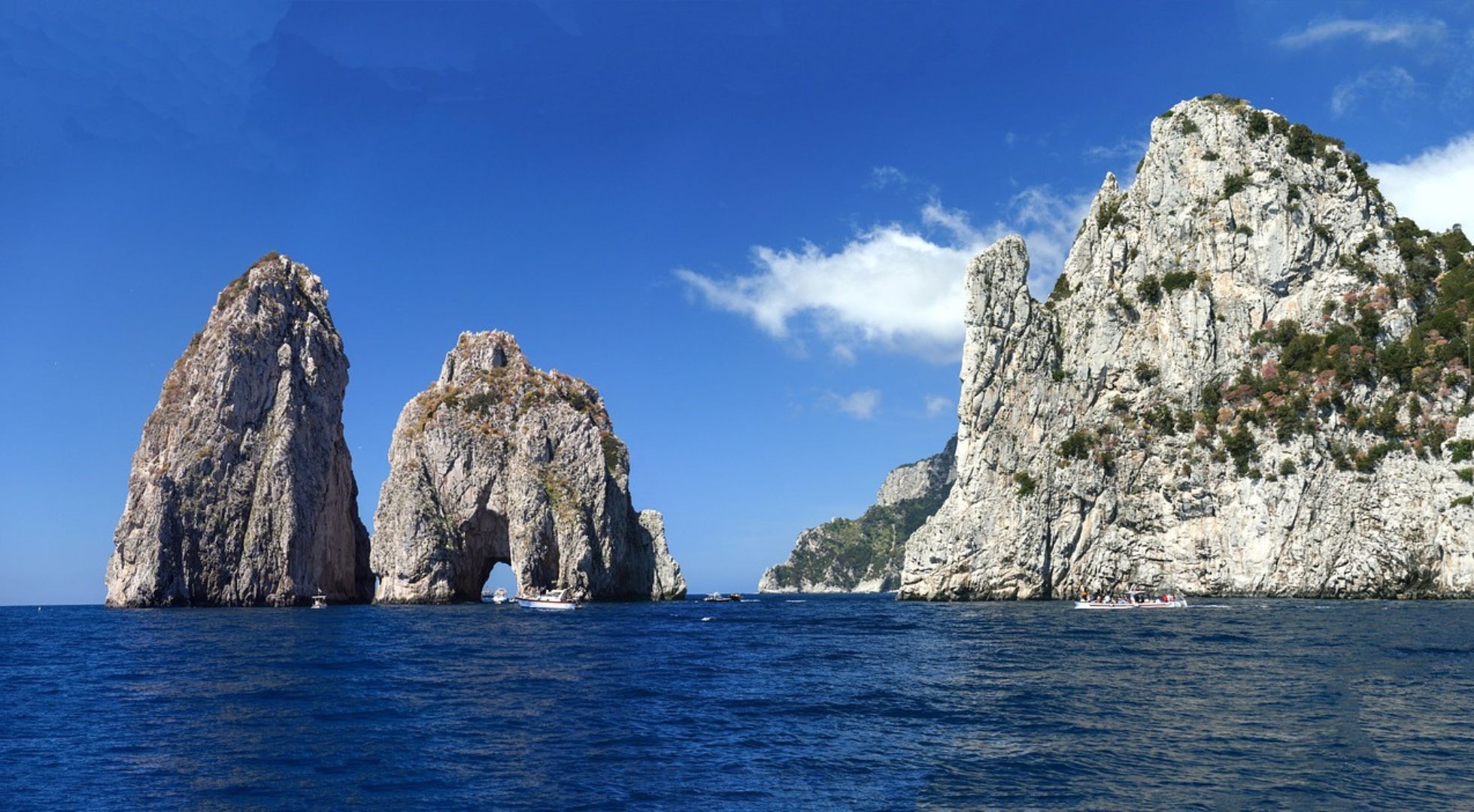 Italy travel guide image of the Faraglioni Rocks in the sea. 