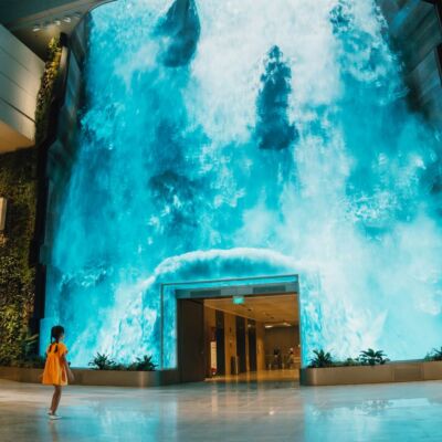 Be transported to a captivating realm as a grand digital waterfall descends at Changi Airport T2's departure hall